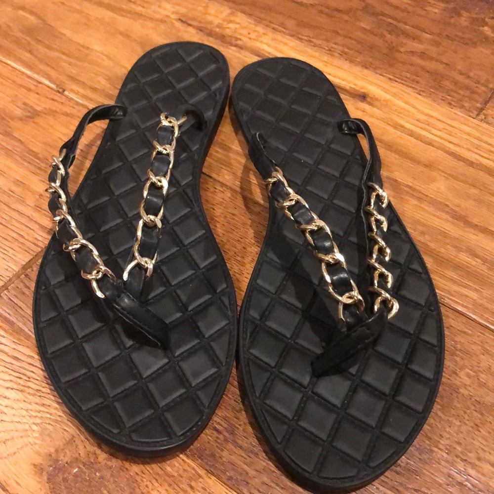 Black flip flops with gold chain accents